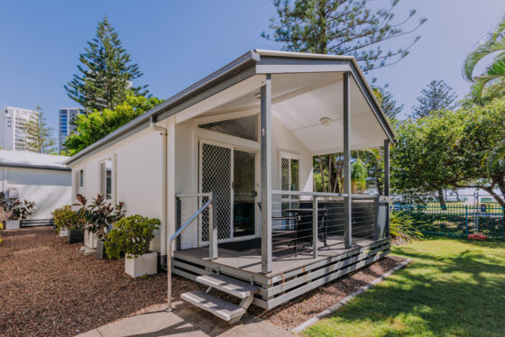 Exterior of a 2 bedroom cabin at Main Beach Tourist Park, featuring a private patio with BBQ.