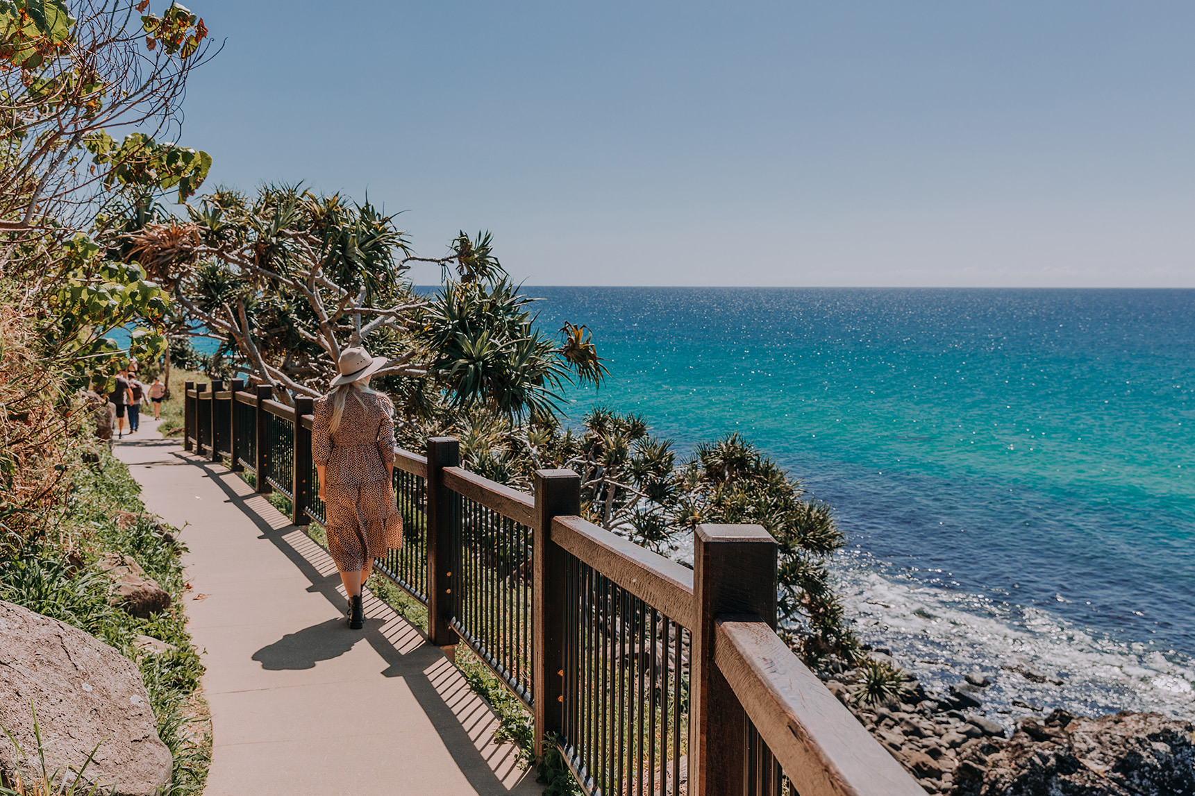 A woman walking along a oceanside trail in Burleigh Heads.