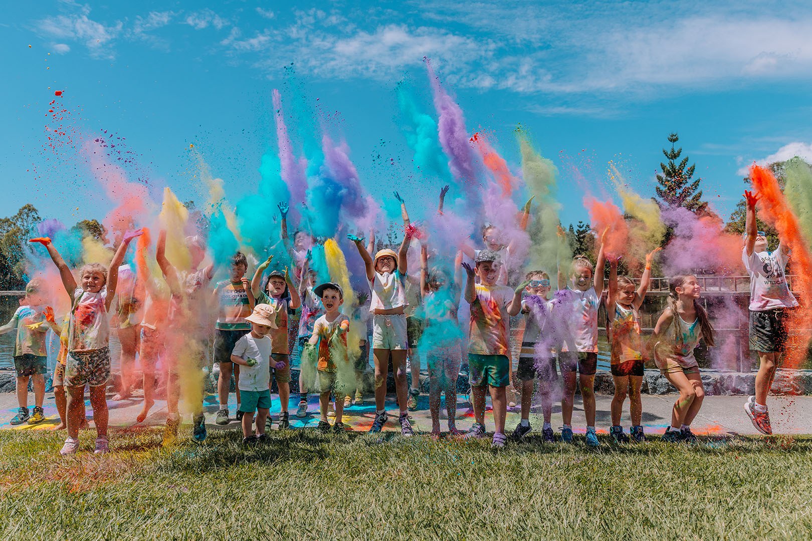 Kids throwing colourful powder in the air at the Burleigh Beach Tourist Park Kids Colour Run.