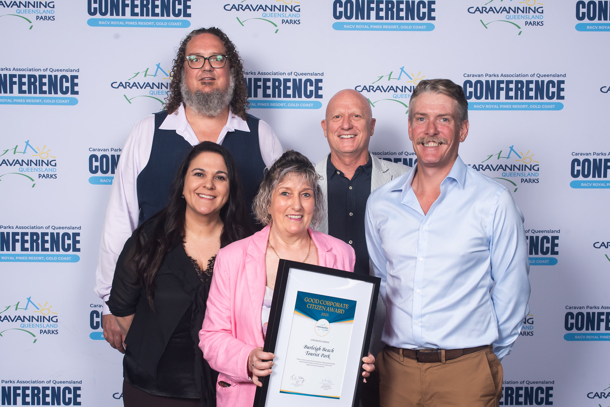 Burleigh Beach Tourist Park staff members at the CPAQ awards night, smiling and holding their award plaque.