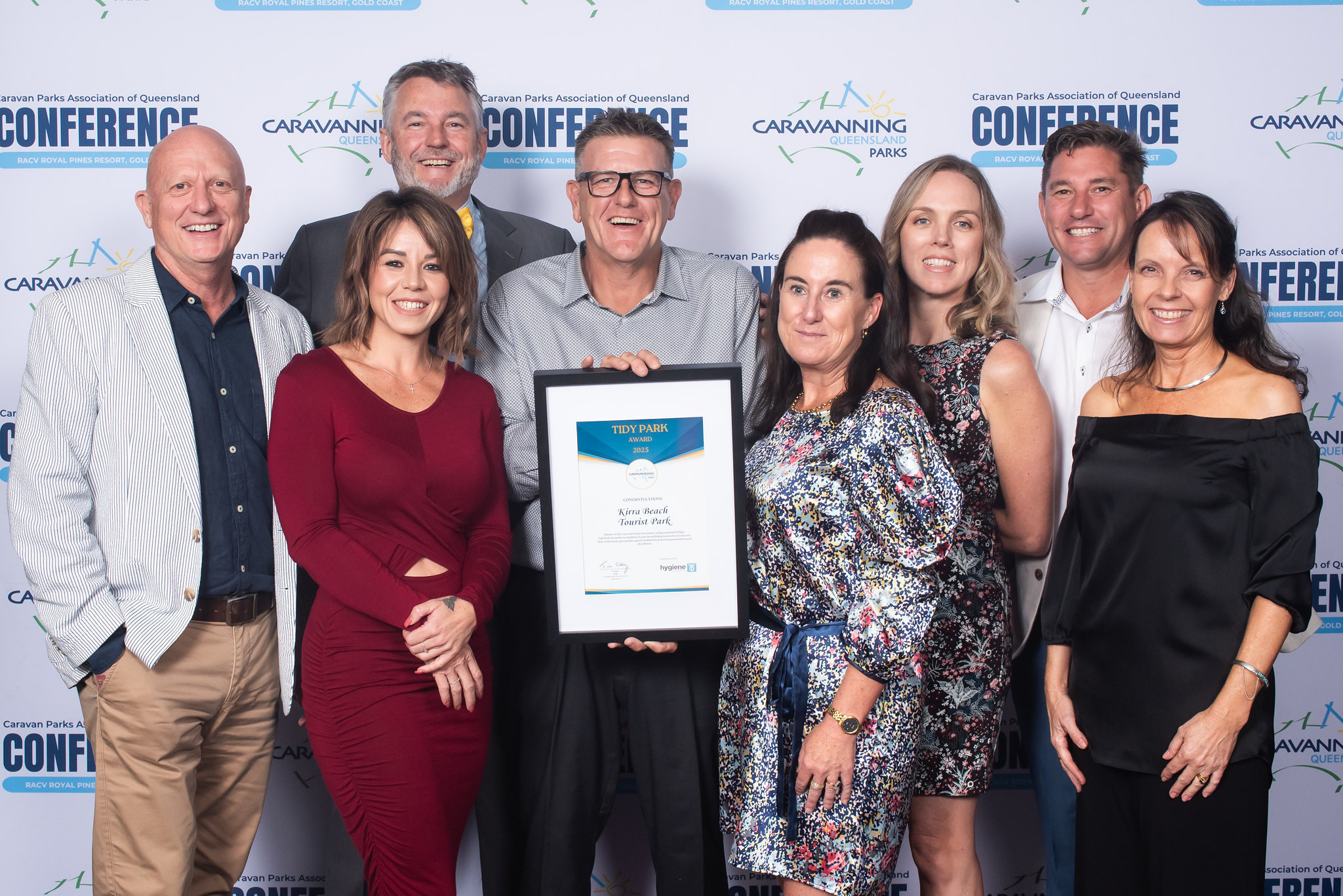 Kirra Beach Tourist Park staff members at the CPAQ awards night, smiling and holding their award plaque.