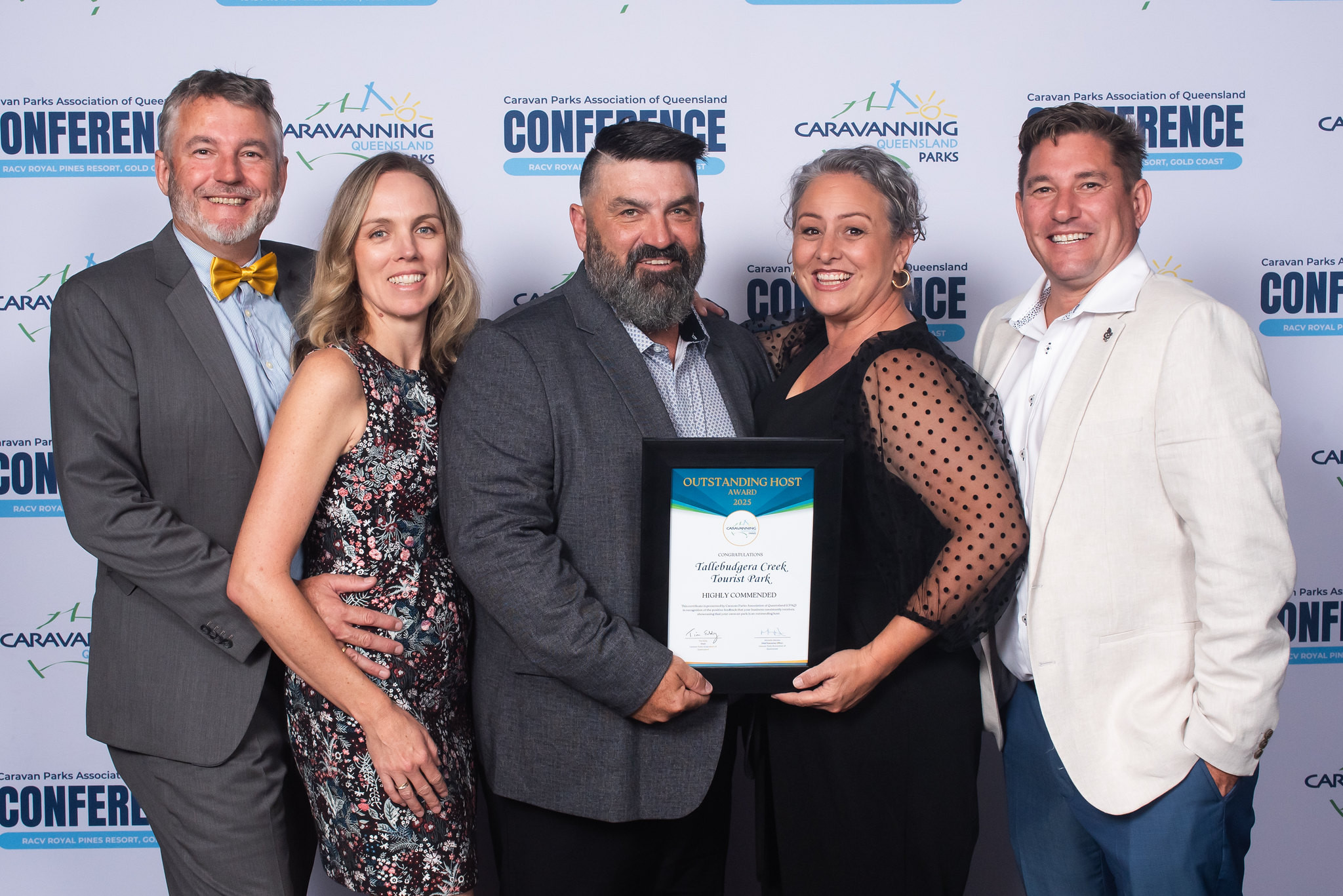 Tallebudgera Creek Tourist Park staff members at the CPAQ awards night, smiling and holding their award plaque.